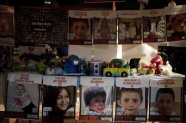 Posters of children held hostage by Hamas in the Gaza Strip are displayed with toys across from the Kirya, headquarters of Israel’s Defense Forces ahead of an anticipated hostage release, in Tel Aviv, Israel, Thursday, Nov. 23, 2023. (AP Photo/Maya Alleruzzo)