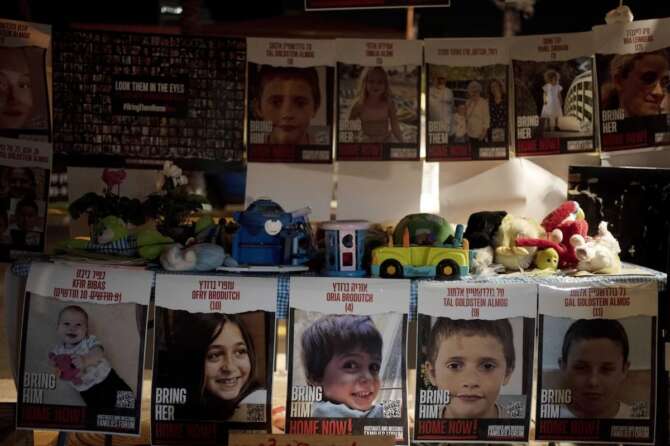 Posters of children held hostage by Hamas in the Gaza Strip are displayed with toys across from the Kirya, headquarters of Israel’s Defense Forces ahead of an anticipated hostage release, in Tel Aviv, Israel, Thursday, Nov. 23, 2023. (AP Photo/Maya Alleruzzo)