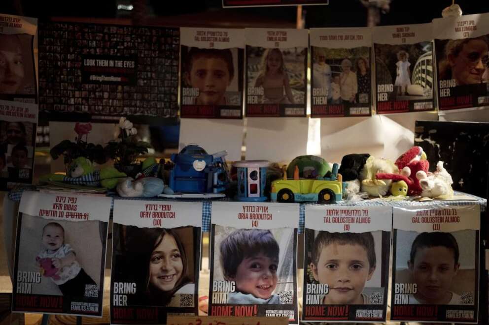 Posters of children held hostage by Hamas in the Gaza Strip are displayed with toys across from the Kirya, headquarters of Israel’s Defense Forces ahead of an anticipated hostage release, in Tel Aviv, Israel, Thursday, Nov. 23, 2023. (AP Photo/Maya Alleruzzo)
