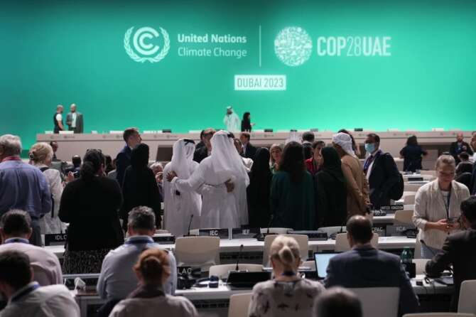 Delegates arrive for a plenary session at the COP28 U.N. Climate Summit, Wednesday, Dec. 13, 2023, in Dubai, United Arab Emirates. (AP Photo/Kamran Jebreili)