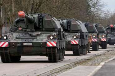German soldiers load tank howitzers for transport to Lithuania at the Bundeswehr army base in Munster, northern Germany, Monday, Feb. 14, 2022. Germany gears up the Enhanced Forward Presence Battle Group in Lithuania at the NATO eastern front. (AP Photo/Martin Meissner)