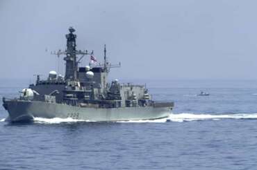 The British frigate HMS Lancaster sails as Iranian Revolutionary Guard vessels follow behind it in the Strait of Hormuz Friday, May 19, 2023. The Mideast-based chiefs of the U.S., British and French navies transited the Strait of Hormuz on Friday aboard an American warship, a sign of their unified approach to keep the crucial waterway open after Iran seized two oil tankers. (AP Photo/Jon Gambrell)