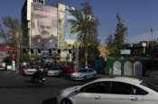 Vehicles drive past a banner showing a portrait of the late Iranian Revolutionary Guard Gen. Mohammad Reza Zahedi who was killed in an airstrike widely attributed to Israel on Monday in Syria, on a building at the Felestin (Palestine) Sq. in downtown Tehran, Iran, Wednesday, April 3, 2024. The sign in Hebrew reads a quotation of Iranian Supreme Leader: “You will be punished by our brave people and we are making you regret.” (AP Photo/Vahid Salemi)