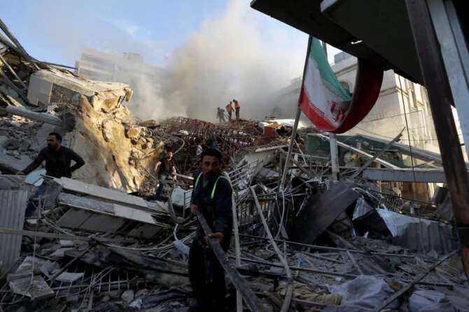 Emergency services work at a destroyed building hit by an air strike in Damascus, Syria, Monday, April 1, 2024. An Israeli airstrike has destroyed the consular section of Iran\’s embassy in Damascus, killing or wounding everyone inside, Syrian state media said Monday. (AP Photo/Omar Sanadiki)