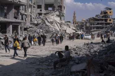 Palestinians walk through the destruction in the wake of an Israeli air and ground offensive in Khan Younis, southern Gaza Strip, Monday, April 8, 2024. Israel says it has withdrawn its last ground troops from the city, ending a four-month operation. (AP Photo/Fatima Shbair)