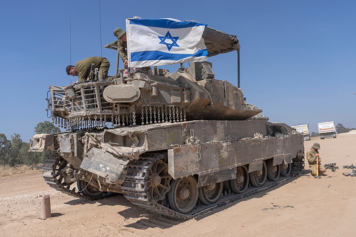 An Israeli soldier attaches an Israeli flag on top of an armoured personnel carriers (APC) near Israel’s border with Gaza, in southern Israel, Monday, April 15, 2024. (AP Photo/Ohad Zwigenberg) Associated Press / LaPresse Only italy and Spain
