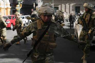 A soldier gestures for journalists to leave Plaza Murillo as soldiers gather near the presidential palace in Plaza Murillo in La Paz, Bolivia, Wednesday, June 26, 2024. (AP Photo/Juan Karita)