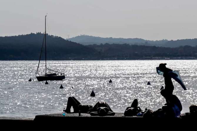Foto Spada/LaPresse 30 Ottobre 2022 – ( Moniga del Garda ) , Italia – cronaca – Turisti in spiaggia al lago di Garda per il week-end Nella foto: i turisti nella spiaggia di Moniga del Garda