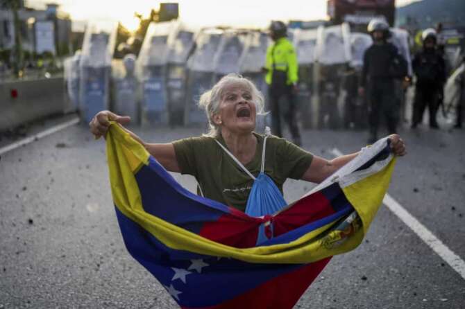 Consuelo Marquez holds a Venezuelan flag in front of police blocking demonstrations against the official election results declaring President Nicolas Maduro’s reelection, the day after the vote in Caracas, Venezuela, Monday, July 29, 2024. (AP Photo/Matias Delacroix) Associated Press/LaPresse