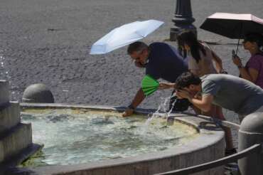 People try to get some relief cooling off at a fountain as temperatures are reaching up to 39 degrees Celsius (102.20 Fahrenheit) in Rome, Monday, July 29, 2024. (AP Photo/Gregorio Borgia) Associated Press/LaPresse