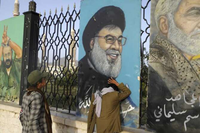 Yemenis stand in front of a portrait of Hezbollah leader Sayyed Hassan Nasrallah, in Sanaa, Yemen, Saturday, Sept. 28, 2024. (AP Photo/Osamah Abdulrahman)