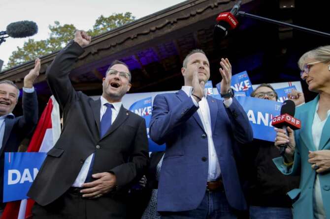 Michael Schnedlitz, right, and Christian Hafenecker of the Freedom Party of Austria cheer at the party headquarters in Vienna, Austria, Sunday, Sept. 29, 2024 upon seeing initial electoral projections. (AP Photo/Heinz-Peter Bader)