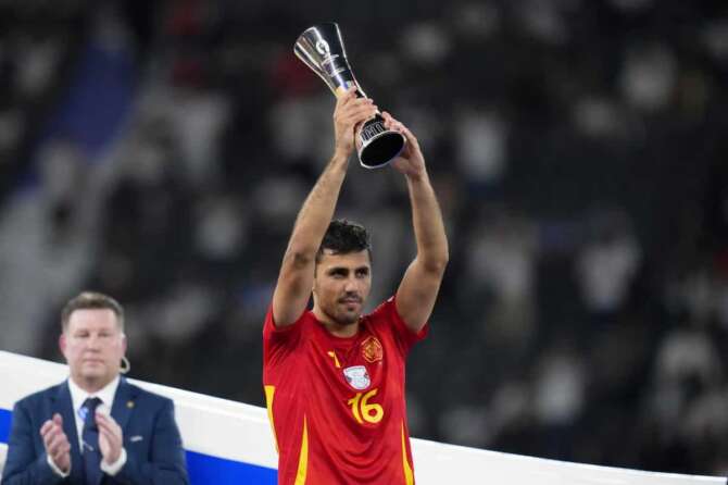 Spain’s Rodri holds up the Best Player of the tournament trophy after the final match between Spain and England at the Euro 2024 soccer tournament in Berlin, Germany, Sunday, July 14, 2024. Spain won 2-1. (AP Photo/Manu Fernandez)