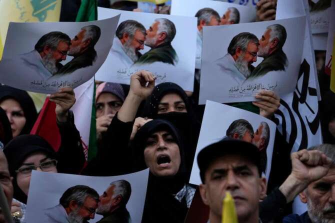 Iranian demonstrators chant slogans as they hold posters showing the late Iranian Revolutionary Guard Gen. Qassem Soleimani, who was killed in Iraq in a U.S. drone attack in 2020, kissing forehead of slain Hezbollah leader Hassan Nasrallah in an anti-Israeli gathering at Felestin (Palestine) Square in Tehran, Iran, Tuesday, Oct. 8, 2024. (AP Photo/Vahid Salemi)