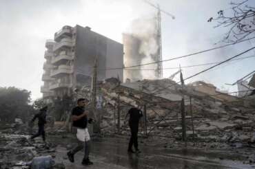 Residents run as smoke rises from a building that collapsed after it was hit by an Israeli airstrike in Chiyah, south of Beirut, Lebanon, Sunday, Nov. 17, 2024. (AP Photo/Bilal Hussein) Associated Press/LaPresse