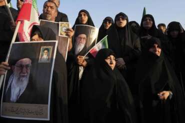 Iranian pro-government demonstrators hold posters of the Supreme Leader Ayatollah Ali Khamenei during their rally condemning recent anti-government protests over the death of Mahsa Amini, a 22-year-old woman who had been detained by the nation’s morality police, in Tehran, Iran, Sunday, Sept. 25, 2022. (AP Photo/Vahid Salemi)
