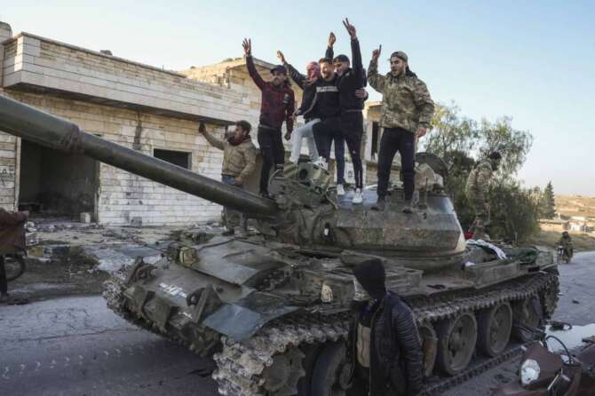 Syrian opposition supporters stand atop a captured Syrian army tank in the town of Maarat al-Numan, southwest from Aleppo, Syria, Saturday Nov. 30, 2024. Thousands of Syrian insurgents have fanned out inside Syria’s largest city Aleppo a day after storming it with little resistance from government troops.(AP Photo/Omar Albam) Associated Press/LaPresse
