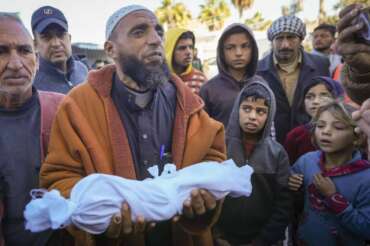 Imam Islam Abu Suaied holds the body of 20-day-old Jomaa al-Batran , who died from hypothermia, before the funeral at Al-Aqsa Martyrs Hospital in central Gaza, Sunday, Dec. 29, 2024. Jomaa’s twin brother, Ali, remains in intensive care, as local health officials report at least three other infant deaths from the cold in recent weeks. (AP Photo/Abdel Kareem Hana) Associated Press/LaPresse