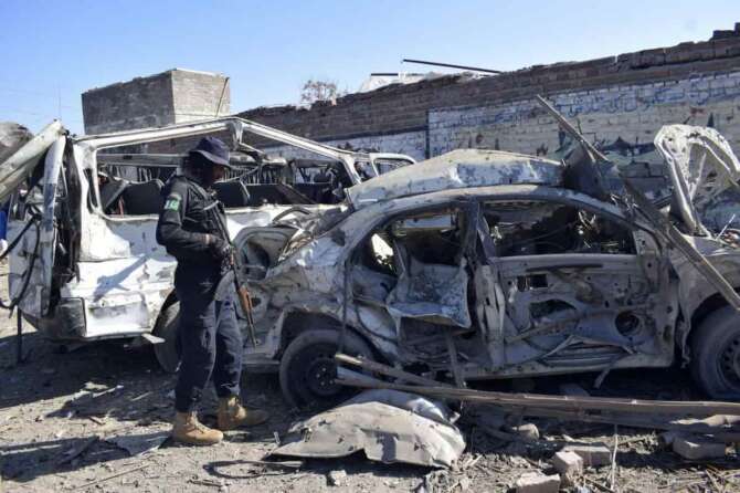 A police officer examines the damaged vehicles at the site of Tuesday’s suicide bombing, in Bannu, in northwestern Pakistan, Wednesday, March 5, 2025. (AP Photo/Ijaz Muhammad)