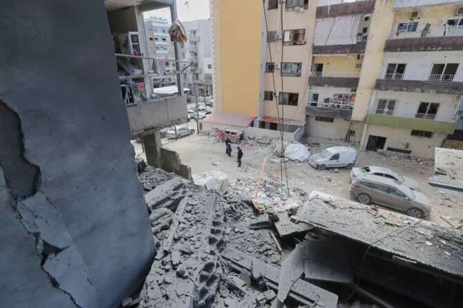 Residents check the site of Saturday’s Israeli airstrike in the southern port city of Tyre, Lebanon, Sunday, March 23, 2025. (AP Photo/Mohammad Zaatari)