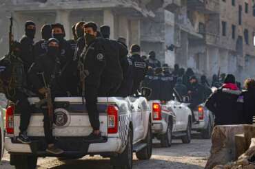Syrian security forces leave the area after an operation in Tadamon, a suburb of Damascus, Syria, Monday, Feb. 17, 2025. Three individuals were arrested accused of being involved in the execution of hundreds of civilians by government forces in Damascus in 2013.(AP Photo/Omar Albam)