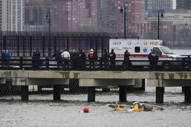 First responders stand on a pier at the scene where a helicopter crashed into the Hudson River, Thursday, April 10, 2025, in Jersey City, N.J. (AP Photo/Seth Wenig) Associated Press / LaPresse Only italy and Spain