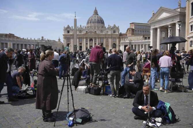 Reporters and media staffers gather in St. Peter’s Square at the Vatican after Cardinal Camerlengo Kevin Joseph Farrell announced the death of Pope Francis, Monday, April 21, 2025. (AP Photo/Andrew Medichini)