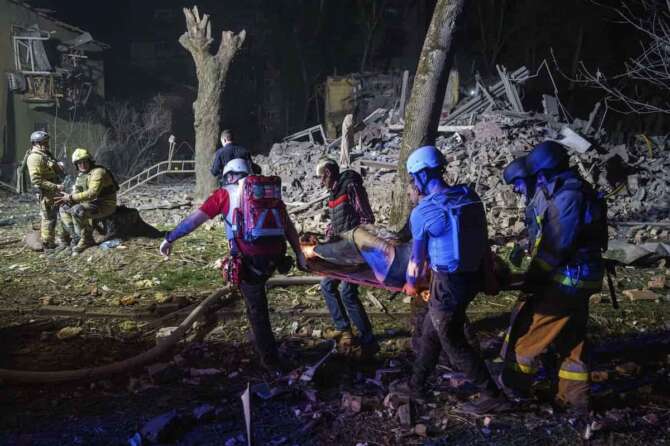 Rescue workers carry an injured victim on a stretcher in front of a house that was destroyed by a Russian strike in a residential neighbourhood in Kyiv, Ukraine, on Thursday, April 24, 2025. (AP Photo/Evgeniy Maloletka)
