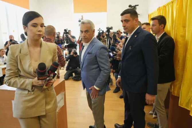Calin Georgescu, winner of the first round of last year’s annulled election, center, and Presidential candidate George Simion exit after casting their votes in the first round of the presidential election redo in Bucharest, Romania, Sunday, May 4, 2025. (AP Photo/Vadim Ghirda)