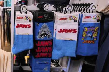 Socks featuring the Jaws movie are displayed at Neptune’s Sea Chest gift shop, Monday, May 12, 2025, in Vineyard Haven, Mass., on Martha’s Vineyard Island. (AP Photo/Charles Krupa) Associated Press / LaPresse Only italy and spain