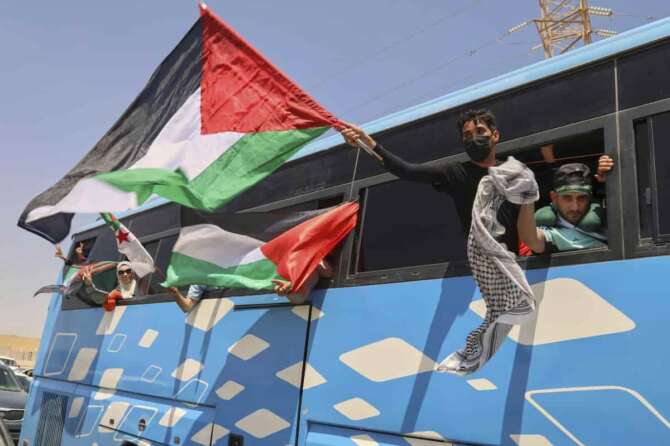Members of a humanitarian convoy of at least 1,500 people, including activists and supporters from Algeria and Tunisia, wave Palestinian flags from a bus as the group travels toward Gaza via Egypt’s Rafah Crossing, in Zawiya, Libya, Tuesday, June 10, 2025. Associated Press / LaPresse Only italy and spain