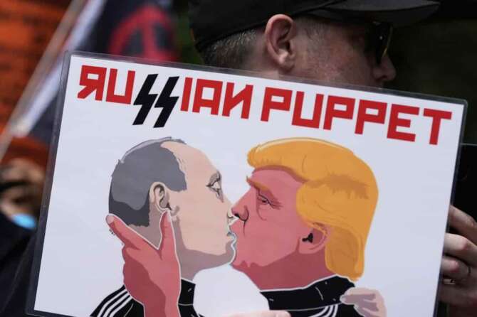 A demonstrators in Lafayette Square near the White House carries a sign depicting Russia’s President Vladimir Putin and President Donald Trump during a protest taking place on the day of a military parade commemorating the Army’s 250th anniversary, coinciding with President Donald Trump’s 79th birthday, Saturday, June 14, 2025, in Washington. (AP Photo/Alex Brandon) Associated Press / LaPresse Only italy and spain