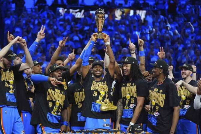 Oklahoma City Thunder guard Shai Gilgeous-Alexander, center, holds up the MVP trophy as he celebrates with his team after they won the NBA basketball championship with a Game 7 victory against the Indiana Pacers Sunday, June 22, 2025, in Oklahoma City. (AP Photo/Julio Cortez) Associated Press/LaPresse