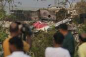 Onlookers watch wreckage from Thursday’s Air India plane crash lying atop a building in Ahmedabad, India, Saturday, June 14, 2025. (AP Photo/Rafiq Maqbool) Associated Press/LaPresse
