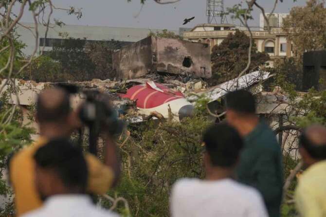 Onlookers watch wreckage from Thursday’s Air India plane crash lying atop a building in Ahmedabad, India, Saturday, June 14, 2025. (AP Photo/Rafiq Maqbool) Associated Press/LaPresse