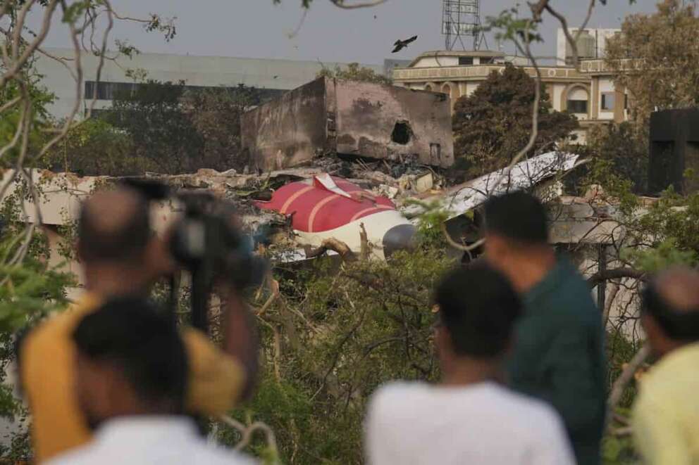 Onlookers watch wreckage from Thursday’s Air India plane crash lying atop a building in Ahmedabad, India, Saturday, June 14, 2025. (AP Photo/Rafiq Maqbool) Associated Press/LaPresse