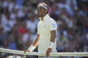 Fabio Fognini of Italy smiles after touching the net and losing the point as he plays Carlos Alcaraz of Spain during their first round men’s singles match at the Wimbledon Tennis Championships in London, Monday, June 30, 2025. (AP Photo/Alastair Grant)
