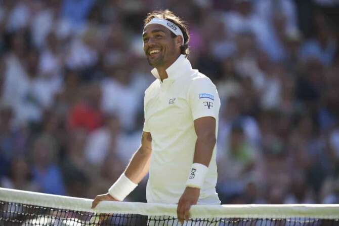 Fabio Fognini of Italy smiles after touching the net and losing the point as he plays Carlos Alcaraz of Spain during their first round men’s singles match at the Wimbledon Tennis Championships in London, Monday, June 30, 2025. (AP Photo/Alastair Grant)
