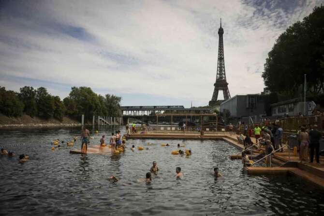 People swim at the Grenelle safe bathing site on the Seine river in Paris, France, Saturday, July 5, 2025, during the opening of the three Seine swimming pools, as part of the ‘Paris Plages’ event. (AP Photo/Thomas Padilla)