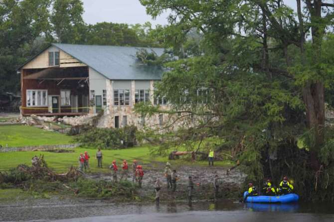 Rescue workers are seen on land and on a boat as they search for missing people near Camp Mystic along the Guadalupe River after a flash flood swept through the area Sunday, July 6, 2025, in Hunt, Texas. (AP Photo/Julio Cortez) Associated Press/LaPresse