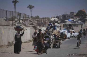 Palestinians flee Deir al-Balah in central Gaza Sunday, July 20, 2025, after the Israeli military issued evacuation orders ahead of expected operations in the area. (AP Photo/Abdel Kareem Hana)