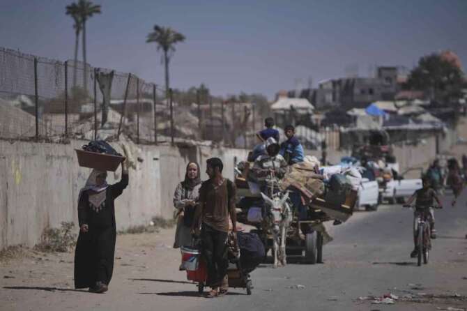 Palestinians flee Deir al-Balah in central Gaza Sunday, July 20, 2025, after the Israeli military issued evacuation orders ahead of expected operations in the area. (AP Photo/Abdel Kareem Hana)