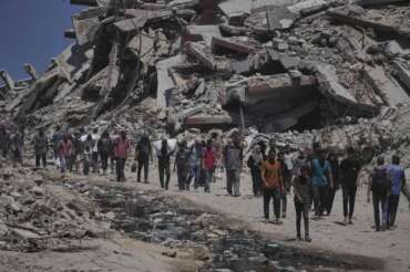 Palestinians carry sacks of humanitarian aid unloaded from trucks convoy that had been heading to Gaza City, in the northern Gaza Strip Sunday, July 20, 2025. (AP Photo/Jehad Alshrafi) Associated Press/LaPresse