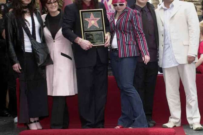 FILE – Metal-rock star Ozzy Osbourne holds a replica of his new star on the Hollywood Walk of Fame as he poses with his family during a ceremony on April 12, 2002, in Los Angeles. Pictured with Osbourne, from left, are Aimee, Sharon, Kelly, Jack and Louis. (AP Photo/Nick Ut, File)