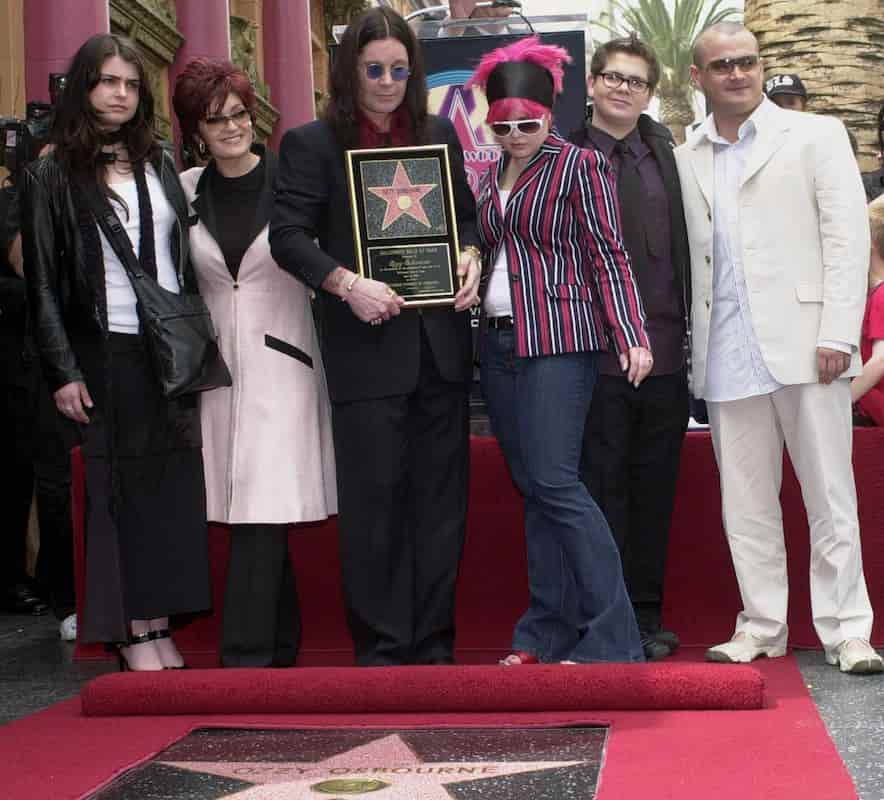FILE – Metal-rock star Ozzy Osbourne holds a replica of his new star on the Hollywood Walk of Fame as he poses with his family during a ceremony on April 12, 2002, in Los Angeles. Pictured with Osbourne, from left, are Aimee, Sharon, Kelly, Jack and Louis. (AP Photo/Nick Ut, File)