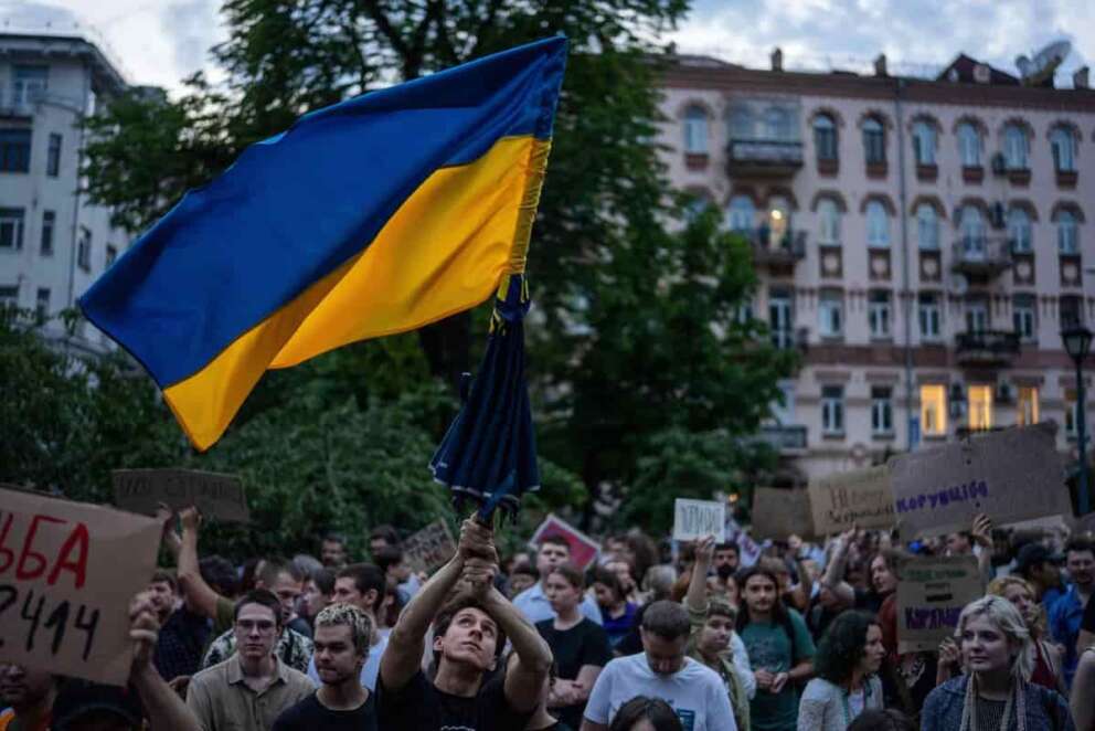 A man waves a flag during a protest against a law targeting anti-corruption institutions in central Kyiv, Ukraine, Tuesday, July 22, 2025. (AP Photo/Alex Babenko)