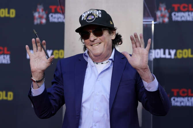 Actor Michael Madsen holds up his hands after writing his name in cement during a ceremony for him at the TCL Chinese Theatre, Monday, Nov. 16, 2020, in Los Angeles. (AP Photo/Chris Pizzello)