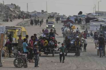 Displaced Palestinians travel on carts and vehicles through a makeshift camp along the beach in Gaza City, Sunday, Aug. 10, 2025. (AP Photo/Jehad Alshrafi)