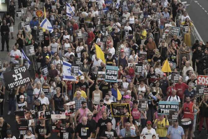 Relatives and supporters of hostages held by Hamas take part in a protest demanding their immediate release and calling for the end of the war in the Gaza Strip, as they march in Tel Aviv, Israel, Thursday, Aug. 21, 2025. (AP Photo/Mahmoud Illean)