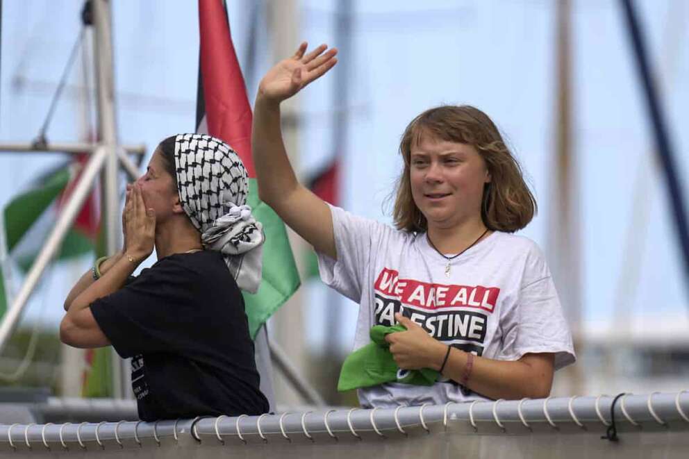 Swedish climate activist Greta Thunberg waves from a boat taking part in a civilian flotilla bound for Gaza, aiming to break the Israeli blockade and deliver humanitarian aid, in Barcelona, Spain, Sunday, Aug. 31, 2025. (AP Photo/Emilio Morenatti)